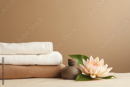 Towels, aroma oils, lotus flower on a beige background, background for spa salons and procedures for rejuvenation and health