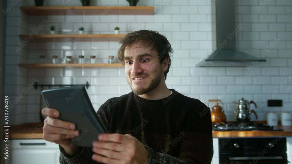 Young adult man standing in a modern kitchen, pressing the keys of a calculator frantically. He drops the calculator, goes mad and yelling screaming. Concept of anger during tax prep season Young adult man standing in a modern kitchen, pressing the keys of a calculator frantically. He drops the calculator, goes mad and yelling screaming. Concept of anger during tax prep season