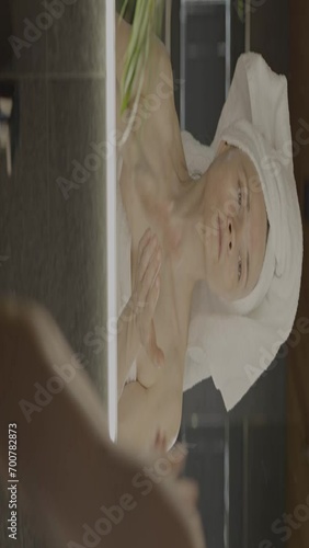 Caucasian female in her 40s is making her daily skin care routine