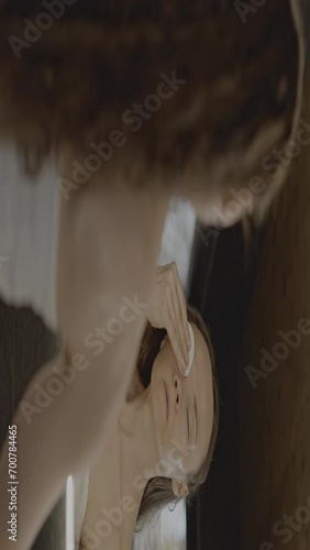 Caucasian female in her 40s is making her daily skin care routine