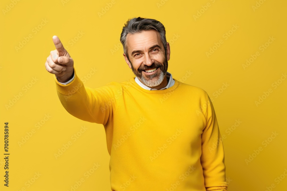 Man wear yellow, show finger point empty space isolated on yellow color background Man wear yellow, show finger point empty space isolated on yellow color background