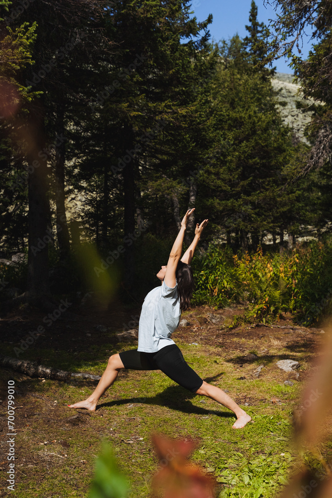Girl practicing yoga in nature in the forest, healthy lifestyle, body care, flexible mind, workout in the park side view, woman standing barefoot on the grass. Girl practicing yoga in nature in the forest, healthy lifestyle, body care, flexible mind, workout in the park side view, woman standing barefoot on the grass.