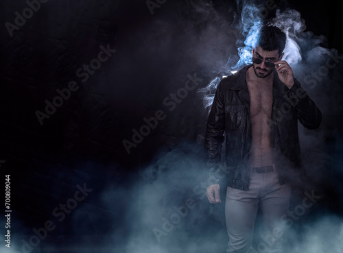 Photo of a shirtless man, with muscular body under leather jacket