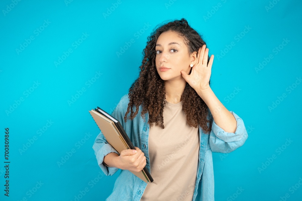 Young beautiful teen woman Trying to hear both hands on ear gesture, curious for gossip. Hearing problem, deaf Young beautiful teen woman Trying to hear both hands on ear gesture, curious for gossip. Hearing problem, deaf