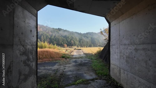 Emerging from narrow tunnel to rural landscape in beautiful morning light photo