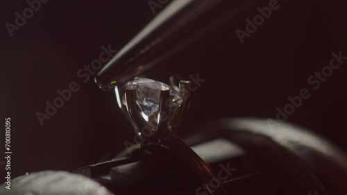 Jeweler Setting Precious Gemstone in Ring with Bright Illumination photo