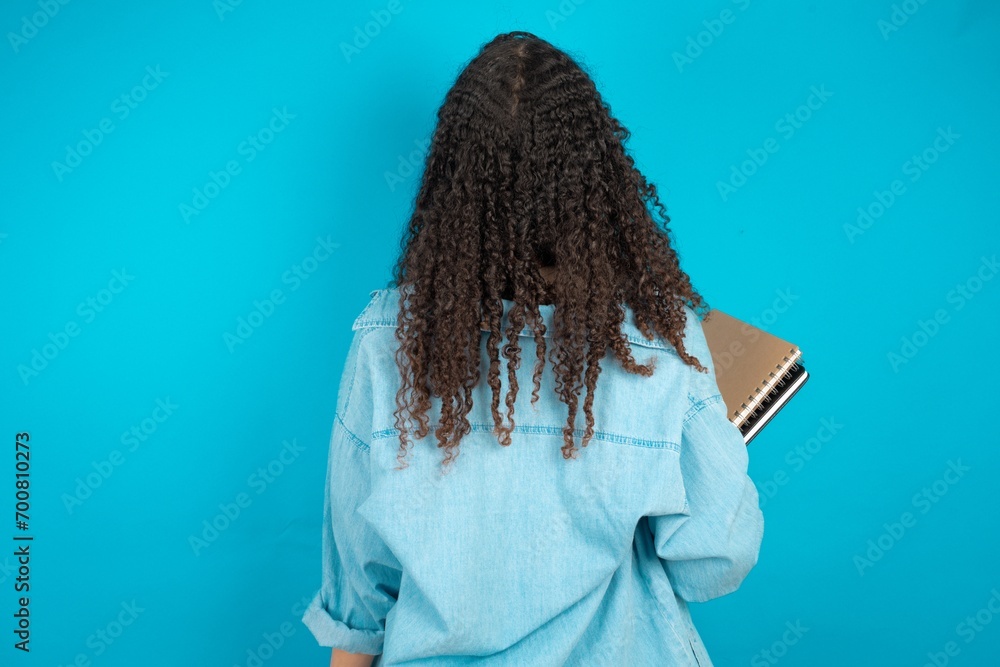 The back view of a beautiful teen girl wearing denim jacket. Studio ...