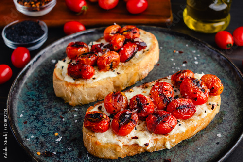 Mascarpone Toast with Burst Tomatoes: Slices of crusty bread topped with creamy cheese, charred grape tomatoes, and extra virgin olive oil