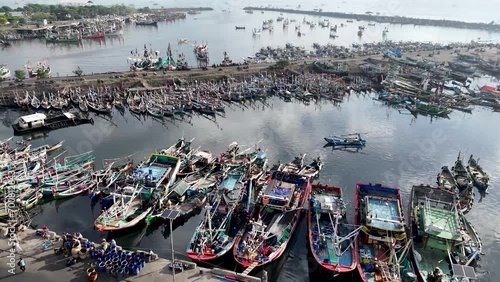 aerial view of the fishing harbor with wooden boats anchored at the pier and the location of unloading the caught fish at sea. at the Muncar fishing pier, Banyuwangi, Indonesia photo