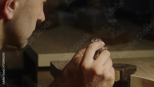 Vintage Jeweler Inspecting Ring through Loupe in Dark Workshop photo