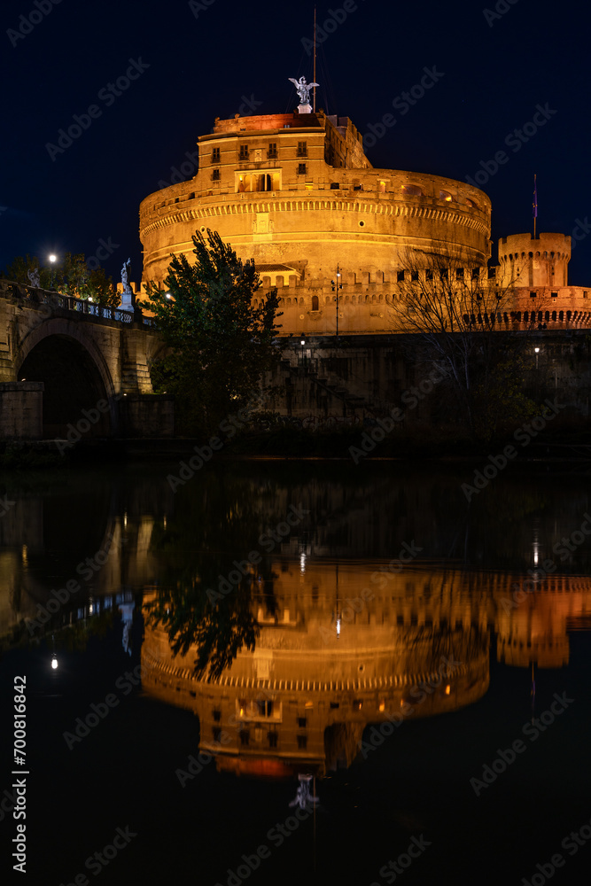 Night view of the Castel Sant'Angelo fortress and the Sant'Angelo bridge reflected in the Tiber river
