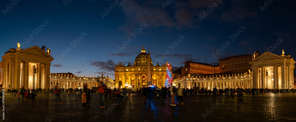 night view of St. Peter's Basilica illuminated and crowded with busy people