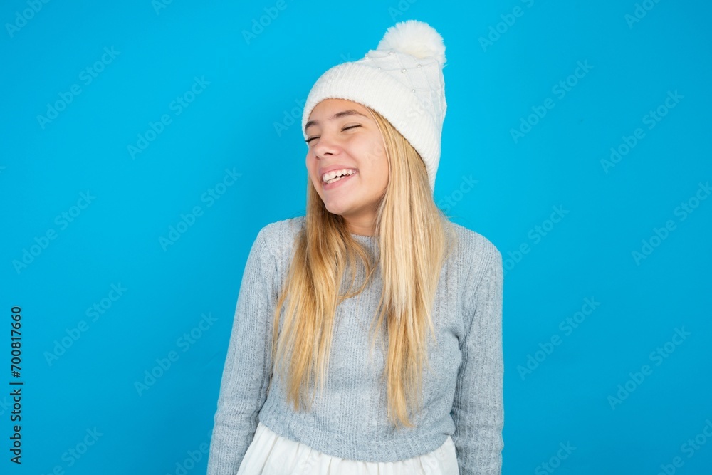 Teen caucasian girl wearing blue knitted sweater and woolly hat very happy and excited about new plans. Teen caucasian girl wearing blue knitted sweater and woolly hat very happy and excited about new plans.