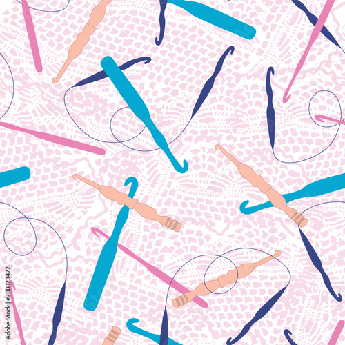 A vector repeat seamless pattern design created with a pink doily texture background with a variety of scattered crochet hooks in teal, pink, navy, blue, and orange.