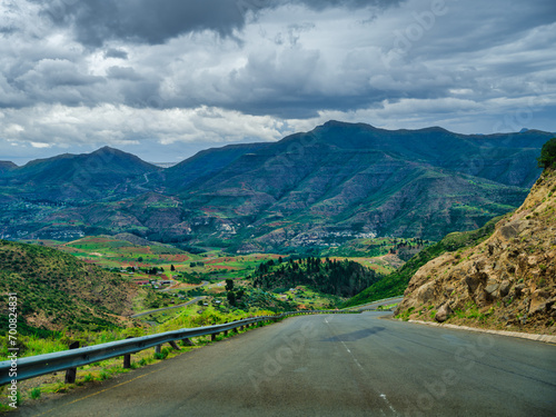 Winding road through Lesotho villages, valleys and mountain during a couldy summer day photo