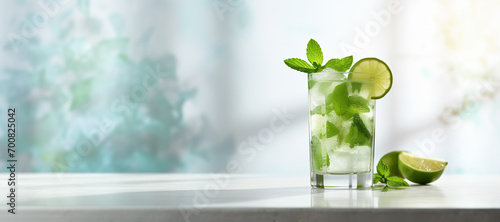 Summer mojito cocktail in a glass with mint and lime on a light background. Bright design for advertising bar, coffee and restaurant. Place for text photo