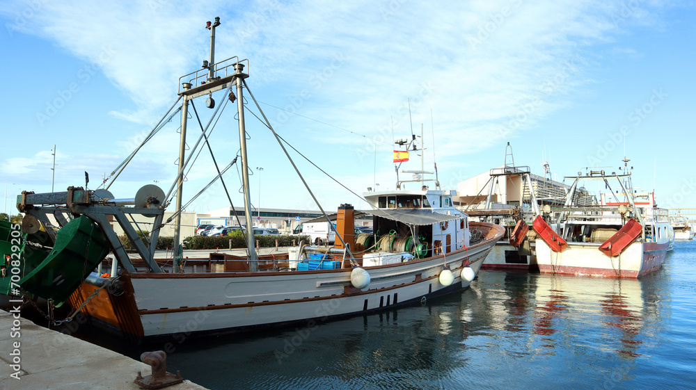 A small fishing ship in the seaport of Spain, view from the stern 