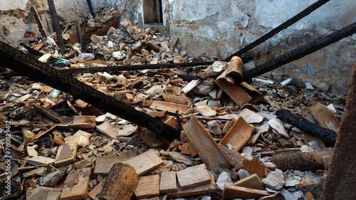 Ruins of a house after a fire, burnt house, charred ceilings, destroyed walls, garbage