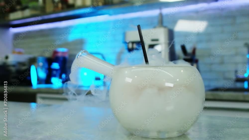 Steam produced by reaction of dry ice and water pouring from bowl neck ...