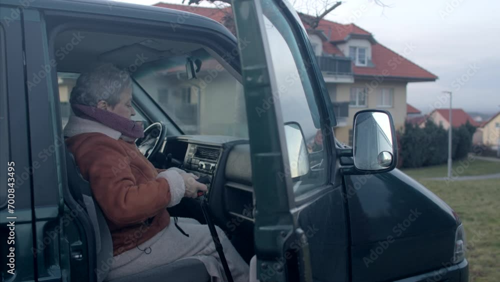 An elderly woman with a cane has difficulty getting out of her car. Overall mobility and independence of seniors, requiring adaptive measures like canes for enhanced stability and safety. An elderly woman with a cane has difficulty getting out of her car. Overall mobility and independence of seniors, requiring adaptive measures like canes for enhanced stability and safety.