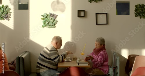 Couple in cafe. An elderly man engages in effective communication through nonviolent communication, combining verbal and nonverbal cues, converses articulately, using gestures to enhance expression. photo