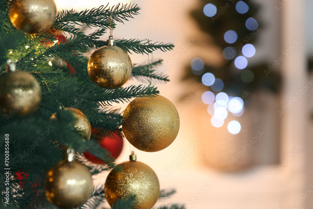 Christmas tree decorated with festive balls on light background, closeup. Space for text