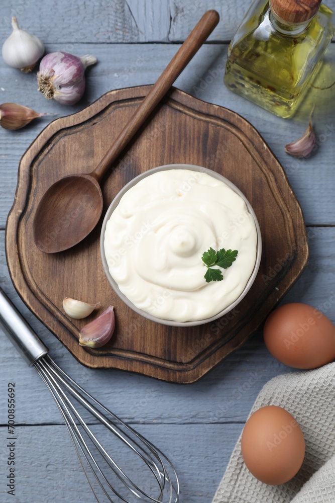 Tasty mayonnaise in bowl, ingredients and whisk on gray wooden table, flat lay Tasty mayonnaise in bowl, ingredients and whisk on gray wooden table, flat lay