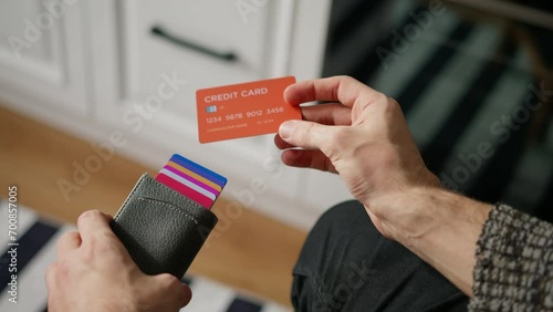 Close-up of young man hand opens card wallet full of credit cards, takes one out photo