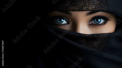 Beautiful Asian woman with a veil covering her face, She is an Arab girl with beautiful eyes. And wear a beautiful patterned hair covering. black background.