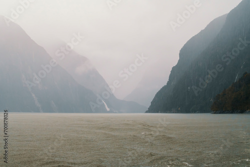 Photograph of low hanging clouds over mountains in Milford Sound in Fiordland National Park on the South Island of New Zealand photo