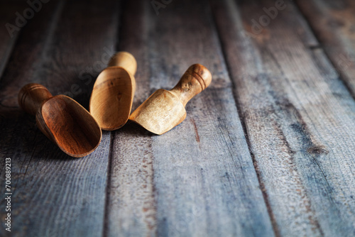 Various wooden scoops of different sizes are placed on a wooden background.