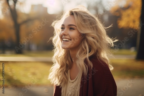 Young blonde woman smiling at the park.
