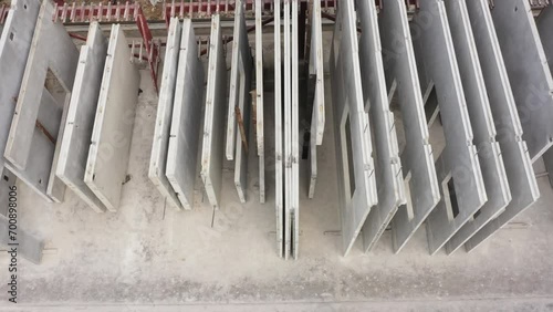 Aerial top view of Precast concrete wall panel for construction building site in warehouse factory. Precast concrete manufacturing products on prefabricated house factory. 4K photo