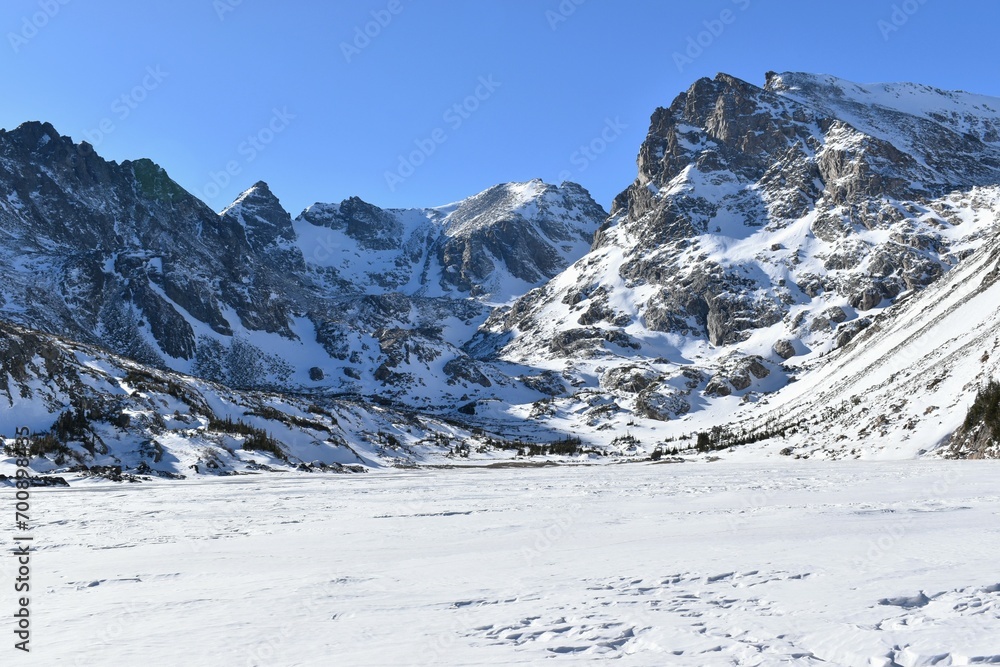 Winter landscape with snow-capped peaks and a frozen lake