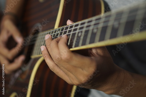 Close-up man playing acoustic guitar