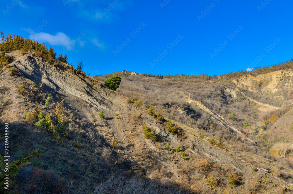 cliffs and pine trees on Mtatsminda mountain scenic view from Narikala trail (Tbilisi, Georgia) cliffs and pine trees on Mtatsminda mountain scenic view from Narikala trail (Tbilisi, Georgia)