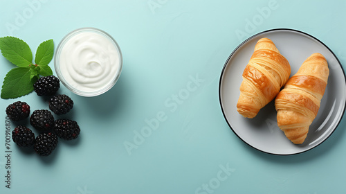 croissant on a plate, breakfast table. Milk on a pale blue background with fresh croissants on turquoise plates. upper view, copy area Yogurt pudding with chia seeds, mint leaves, fresh blackberries