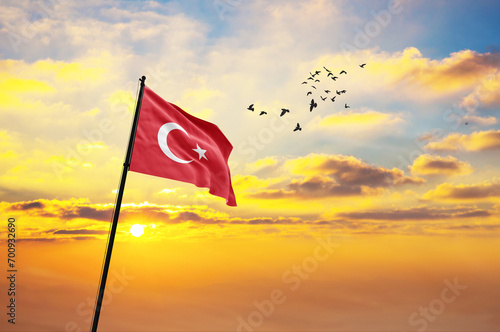 Waving flag of Turkey against the background of a sunset or sunrise. Turkey flag for Independence Day. The symbol of the state on wavy fabric. photo