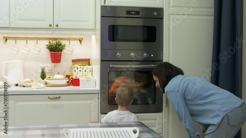 Wallpaper Mural mother and child cooking roasted stuffed turkey in kitchen oven, mom and little boy putting turkey in the oven. Preparing thanksgiving or christmas holiday dinner Torontodigital.ca
