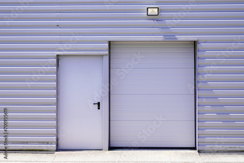 entrance roller gate down shutters on gray building facade door in commercial industrial unit