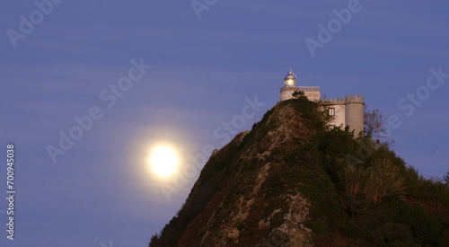 Full moon behind the La Plata lighthouse at sunset in Euskadi