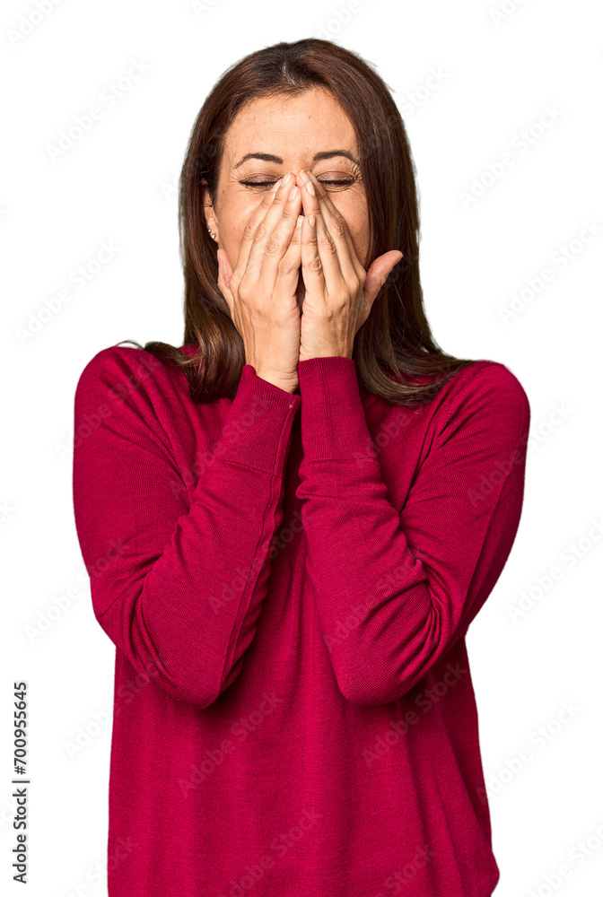 Elegant middle-aged Caucasian woman in studio setting laughing about something, covering mouth with hands. Elegant middle-aged Caucasian woman in studio setting laughing about something, covering mouth with hands.