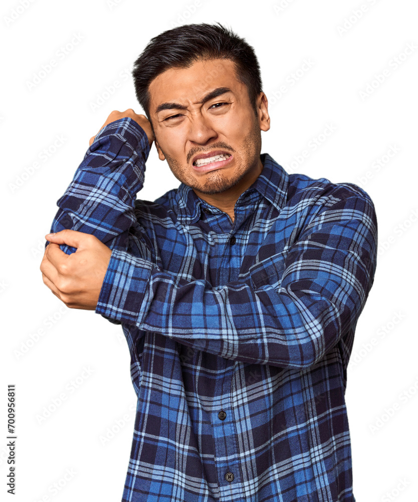 Young Chinese man in studio background massaging elbow, suffering after a bad movement. Young Chinese man in studio background massaging elbow, suffering after a bad movement.
