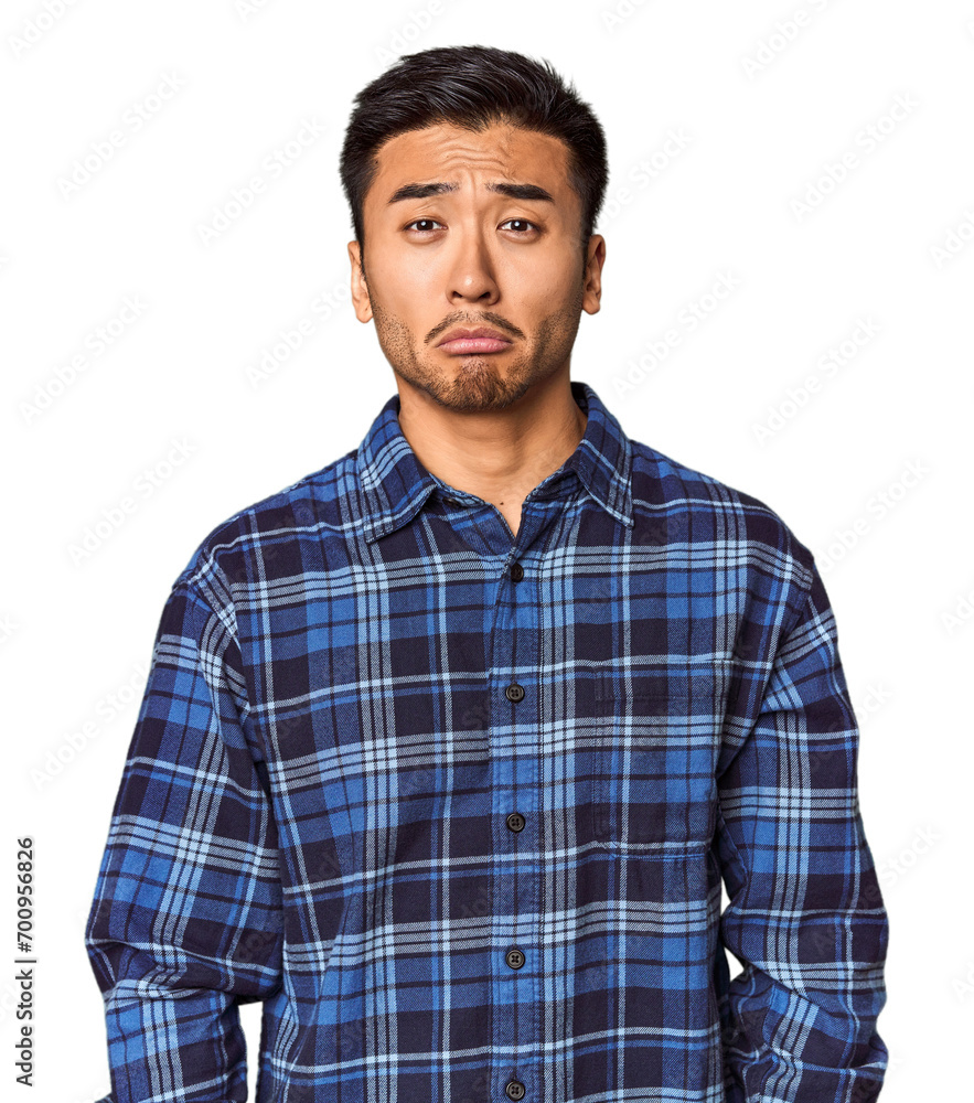 Young Chinese man in studio background sad, serious face, feeling miserable and displeased. Young Chinese man in studio background sad, serious face, feeling miserable and displeased.