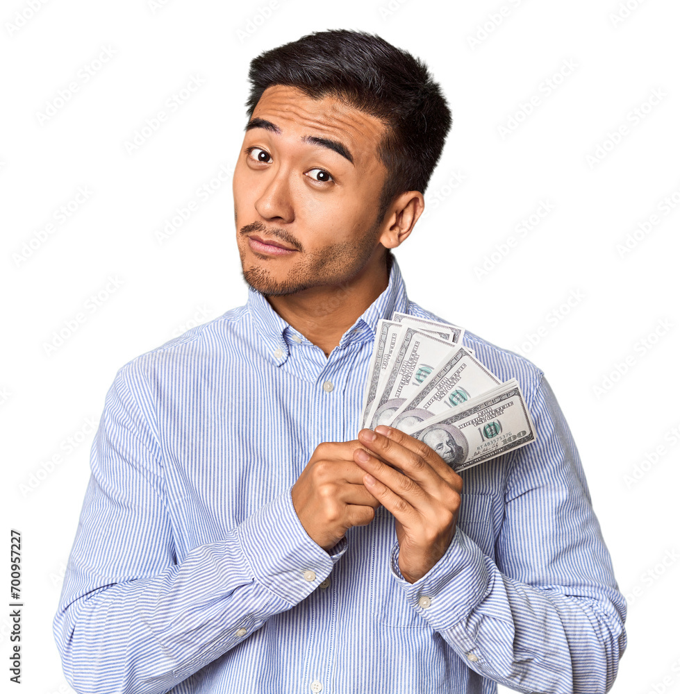Chinese man with cash, celebrating financial victory in studio Chinese man with cash, celebrating financial victory in studio