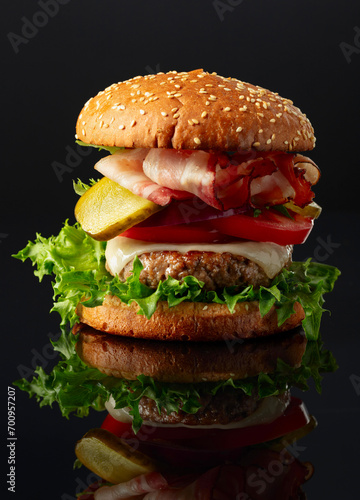 Burger on a black reflective background.