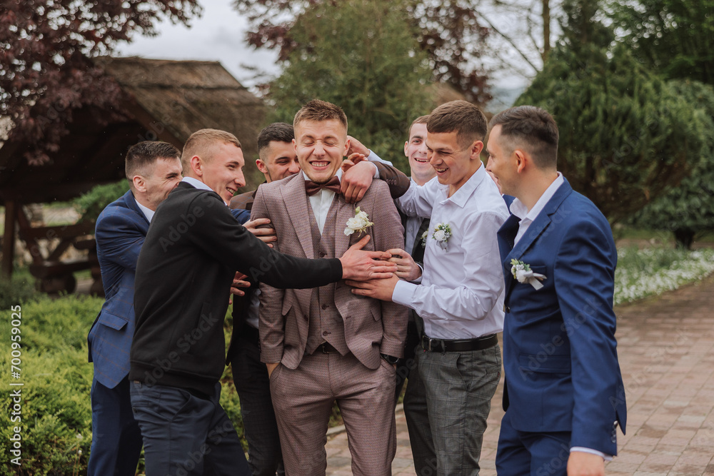 Cheerful, young, energetic witnesses of the groom next to the groom. Friends congratulate the groom. Groom and his funny friends having fun on the wedding day of the newlyweds. Cheerful, young, energetic witnesses of the groom next to the groom. Friends congratulate the groom. Groom and his funny friends having fun on the wedding day of the newlyweds.