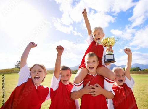 Celebration, soccer team and children with cup, boys and girls with victory, support or proud. Achievement, sports and friendship, together and happy for win, ready for game or physical activity © M Moller/peopleimages.com