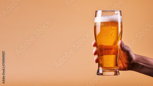Hand holding a glass of beer isolated on pastel background