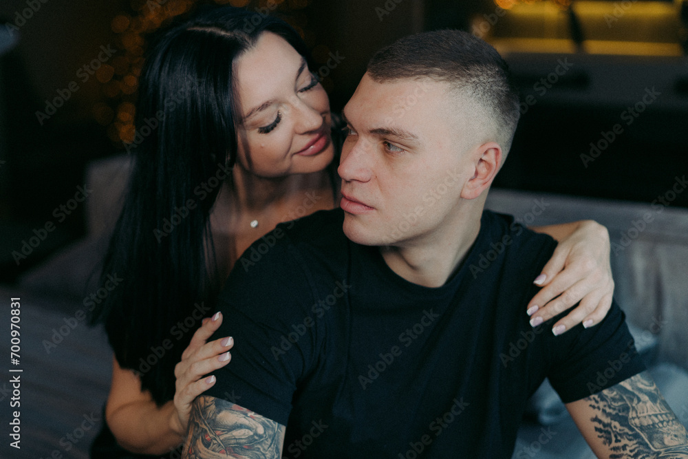 A man and woman sitting on a bed. Young beautiful couple hugging. A man and woman sitting on a bed. Young beautiful couple hugging.